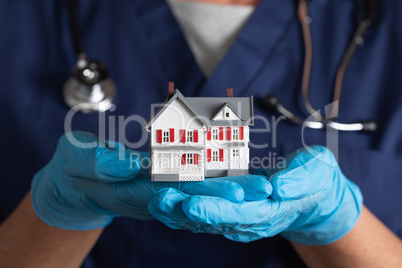 Female Doctor or Nurse Wearing Surgical Gloves Holding Model Hom