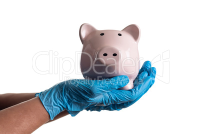 Doctor or Nurse Wearing Surgical Gloves Holding Piggy Bank Isola