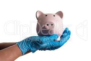 Doctor or Nurse Wearing Surgical Gloves Holding Piggy Bank Isola