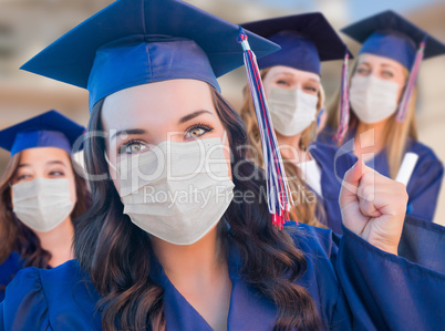 Several Female Graduates in Cap and Gown Wearing Medical Face Ma