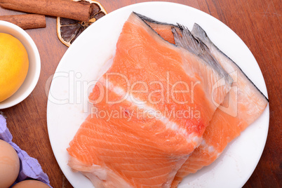 fresh salmon fillet close up on white plate. eggs, cinnamon and lemon