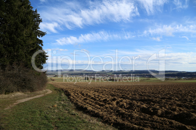 Landscape with a ploughed field and blue sky