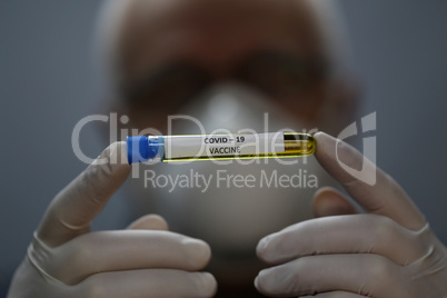 Doctor holds COVID 19 Coronavirus vaccine in his hand