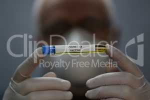 Doctor holds COVID 19 Coronavirus vaccine in his hand