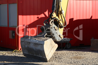 A bucket from the excavator stands on the construction site