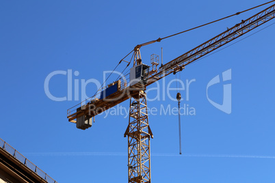 Crane at a construction site on a background of blue sky