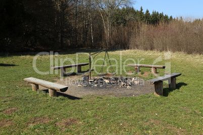 Barbecue area with four wooden benches in the forest