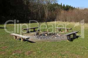Barbecue area with four wooden benches in the forest