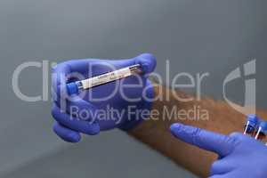 Coronavirus testing - a hand holds test tubes containing patient blood samples with results for coronavirus