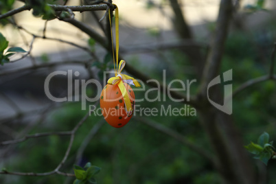 Decorative easter egg made of plastic hanging on a tree