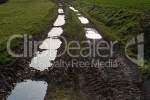 dirty mud road with puddles