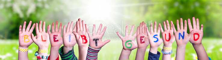 Kids Hands Holding Word Bleibt Gesund Means Stay Healthy, Grass Meadow