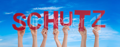 People Hands Holding Word Schutz Means Protection, Blue Sky
