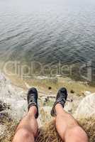 point of view of man sitting on the edge of cliff