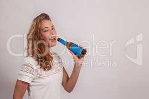 lächelnde Frau trinkt aus einer Flasche
