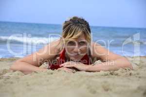 Rebel blonde girl poses lying in swimsuit