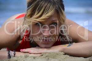 Rebel blonde girl poses lying in swimsuit