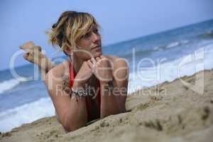 Rebel blonde girl poses lying in swimsuit