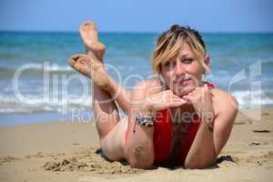 Rebel blonde girl poses lying in swimsuit