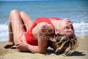 Rebel blonde girl poses sitted in swimsuit