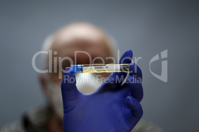 Doctor holds COVID 19 Coronavirus vaccine in his hand