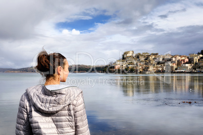 Girl at the lake and small village in the distance.