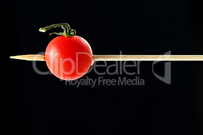 Cherry tomato pricked on a wooden skewer