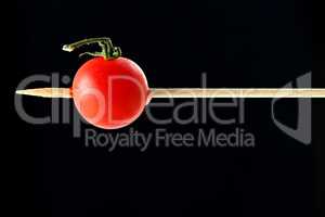 Cherry tomato pricked on a wooden skewer