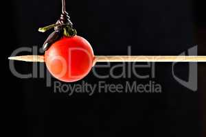 Cherry tomato pricked on a wooden skewer