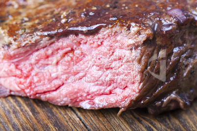 Scheiben eines Steaks auf Holz mit Rosmarin