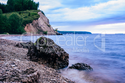 stone on the riverbank and cliff with woodland on background