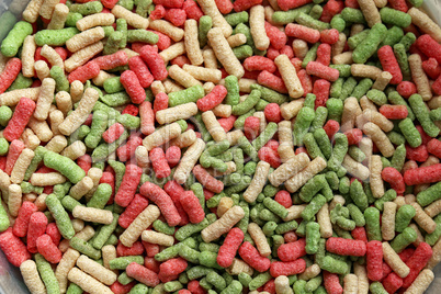 colorful dry food for fish in the form of background
