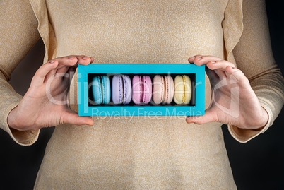 Girl hold colorful macaroons in gift box