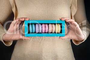 Girl hold colorful macaroons in gift box
