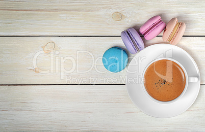 Macaroons and cup with coffee on top