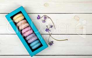 Macaroons in gift box next to violet