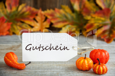 Label With Text Gutschein Means Voucher, Pumpkin And Leaves