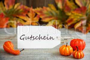Label With Text Gutschein Means Voucher, Pumpkin And Leaves