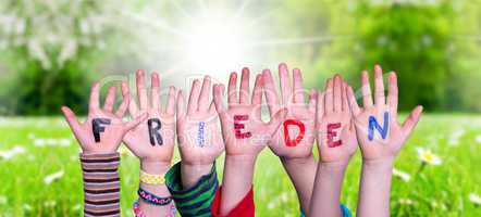 Kids Hands Holding Word Frieden Means Peace, Grass Meadow