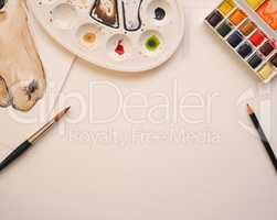 Blank watercolor paper sheet with utensils