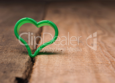Small green heart shape on a rustic wooden table