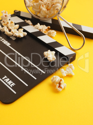 Tasty organic popcorn with a clapboard on yellow