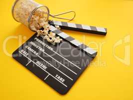 Tasty organic popcorn with a clapboard on yellow