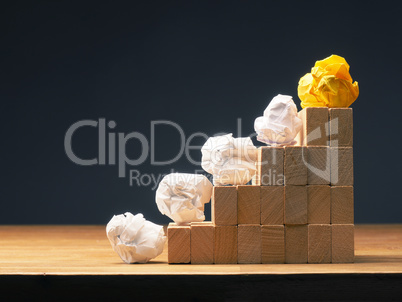 Crumpled paper on wooden stairs, business concept