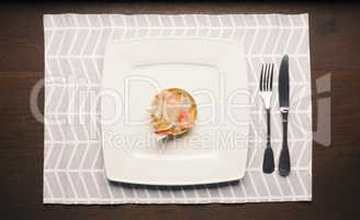 plastic garbage on a plate with cutlery on a wooden table