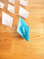 Teamwork business concept with paper boat on a wooden table