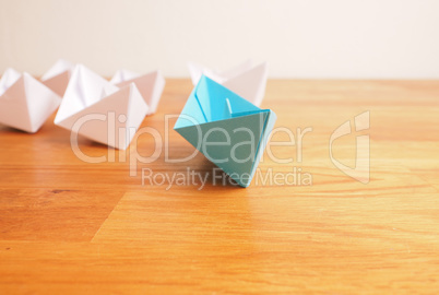 Teamwork business concept with paper boat on a wooden table