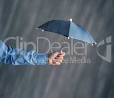 Hand of a businessman with an umbrella in rain