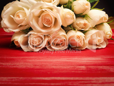 Bouquet of white roses on a red wooden table