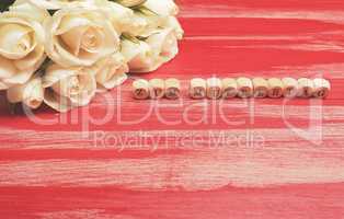 Bouquet of white roses on a red wooden table German Mother's Day